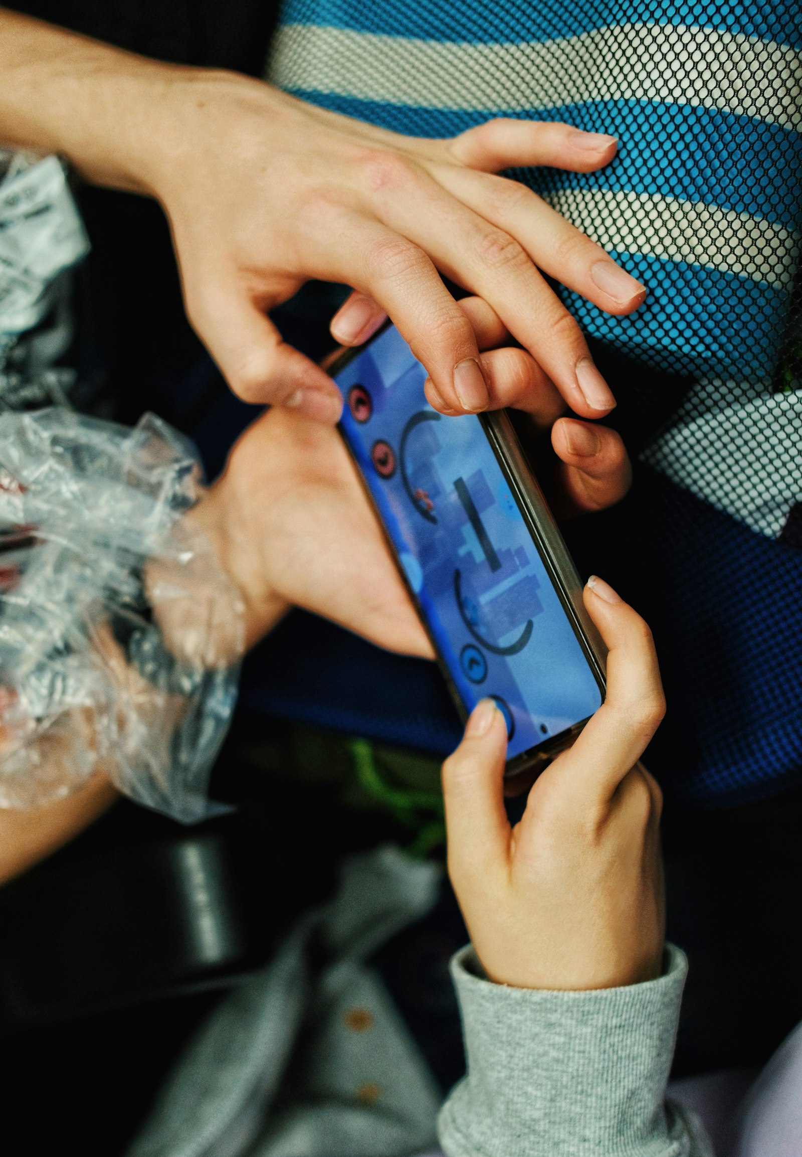Mains tenant un smartphone affichant un jeu d'adresse